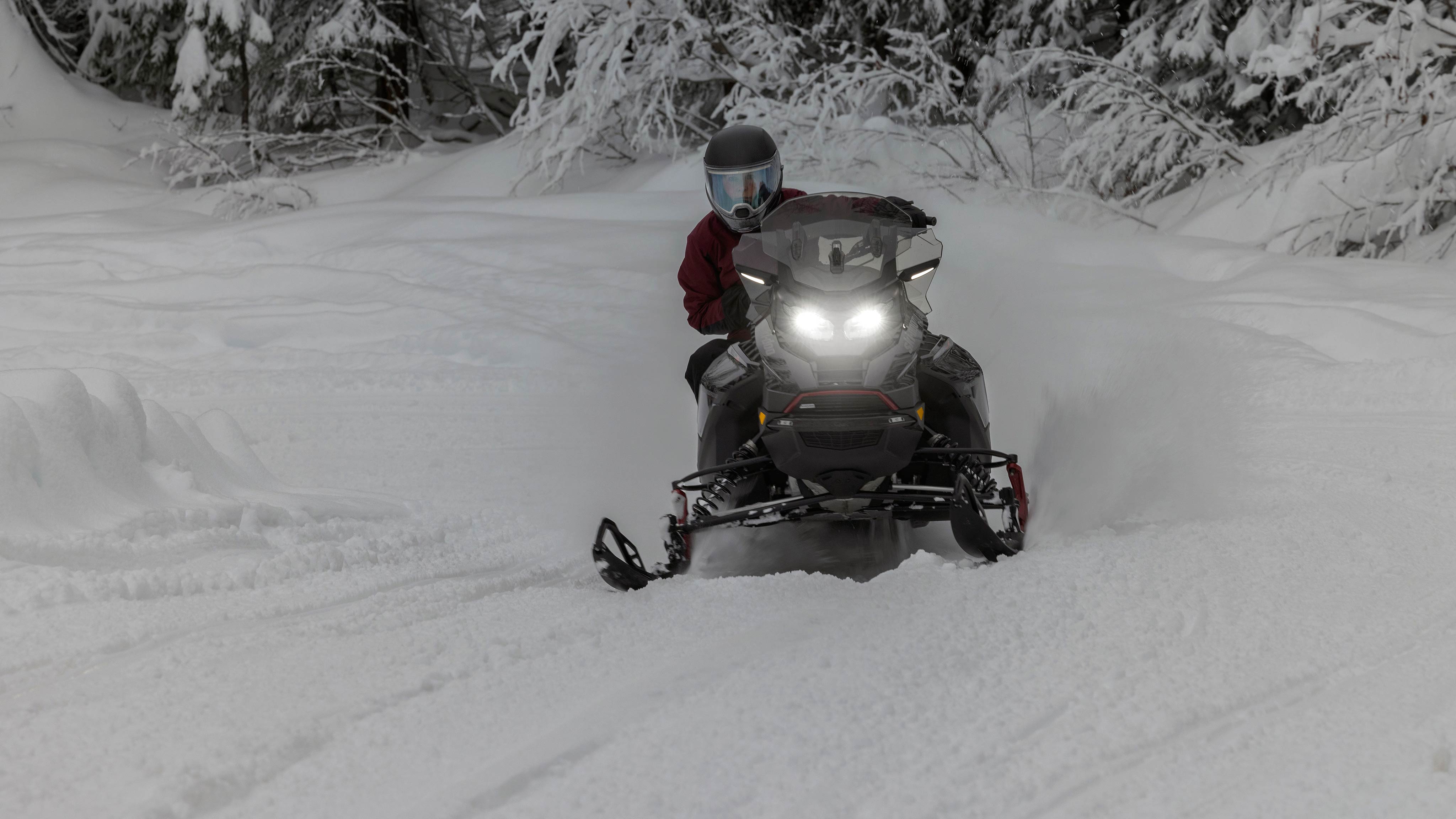 Voznik skrbno krmari po zasneženi poti na Ski-Doo Renegade 2025